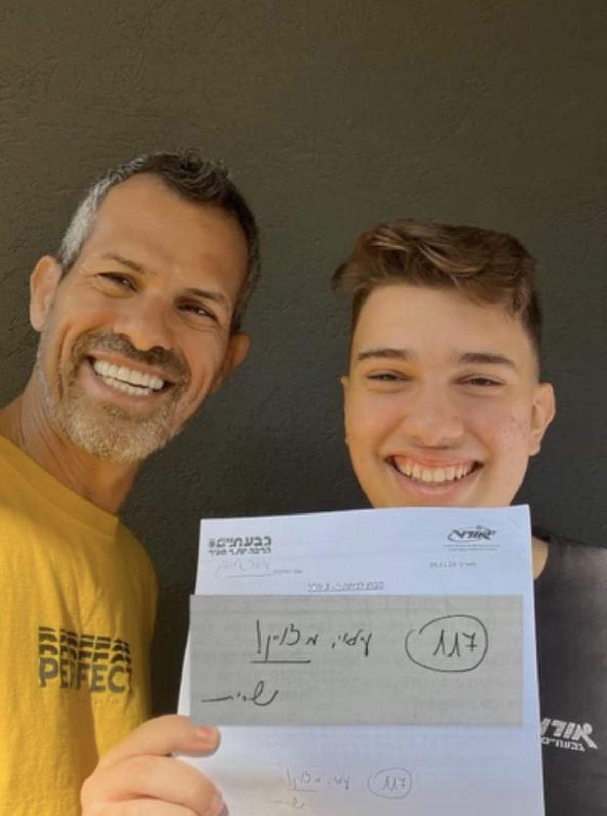 ארז משולמי ותלמיד מחזיק את גיליון הציון